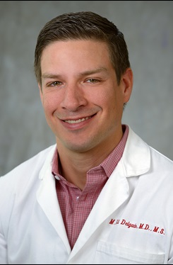 Photo of Dr. M. Kit Delgado in a lab coat 